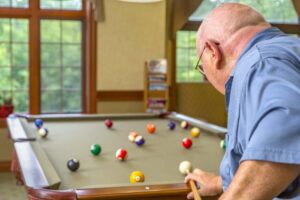 Resident playing pool in the community billiards room